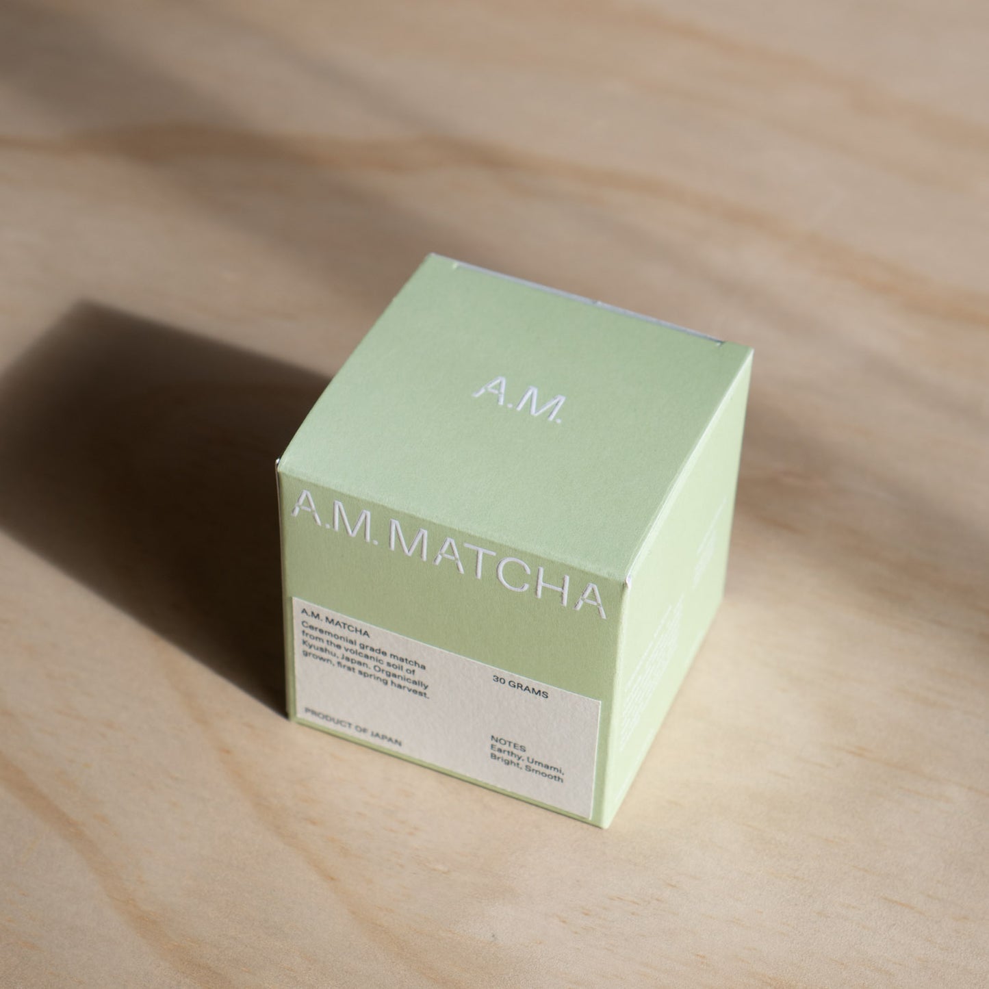 Green box labeled 'A.M. Matcha' on a wooden surface