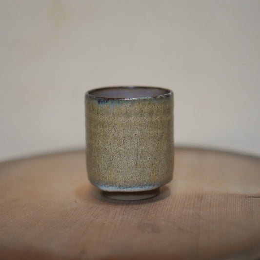 Ceramic cup on a wooden surface with a neutral background