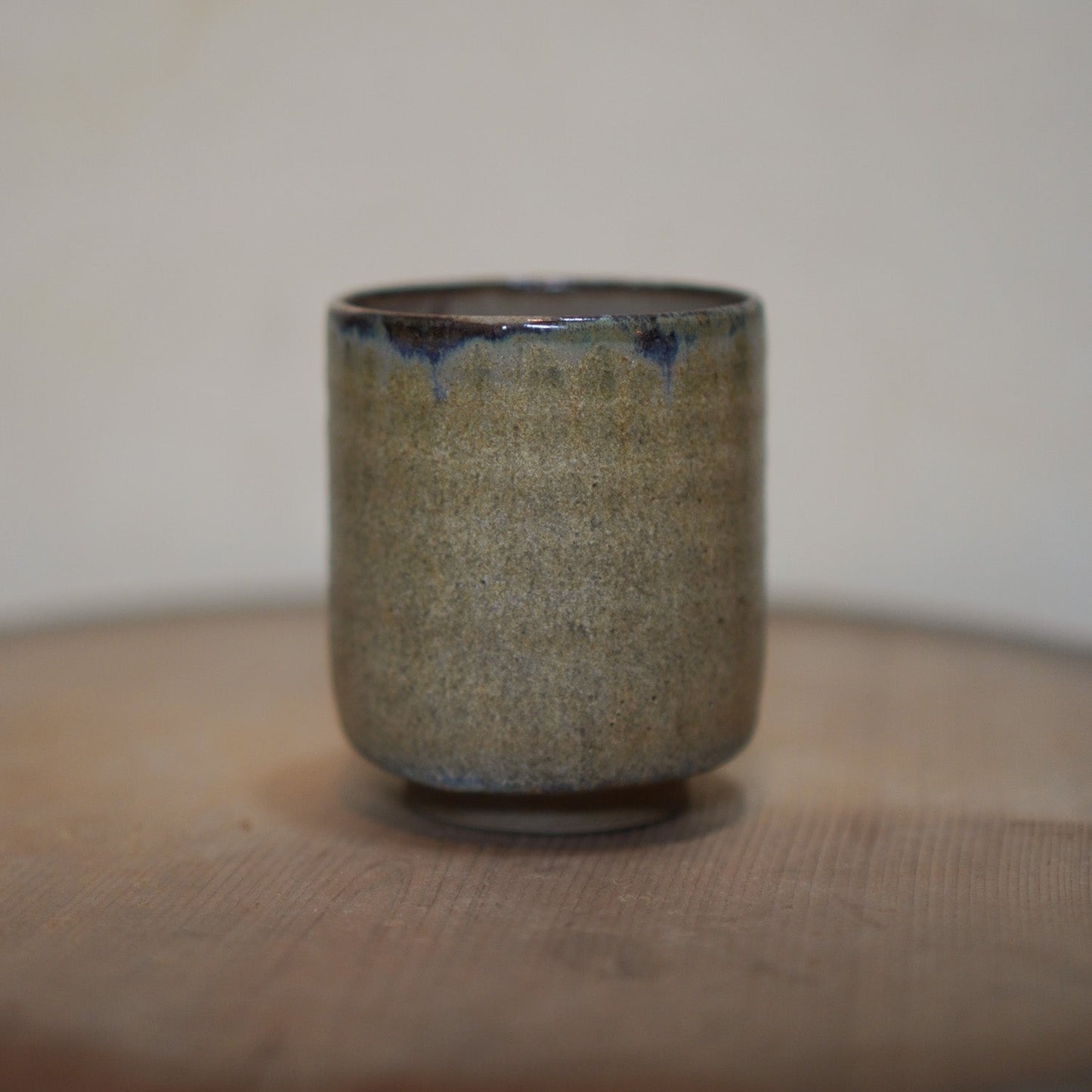 Ceramic cup with textured surface on a wooden surface