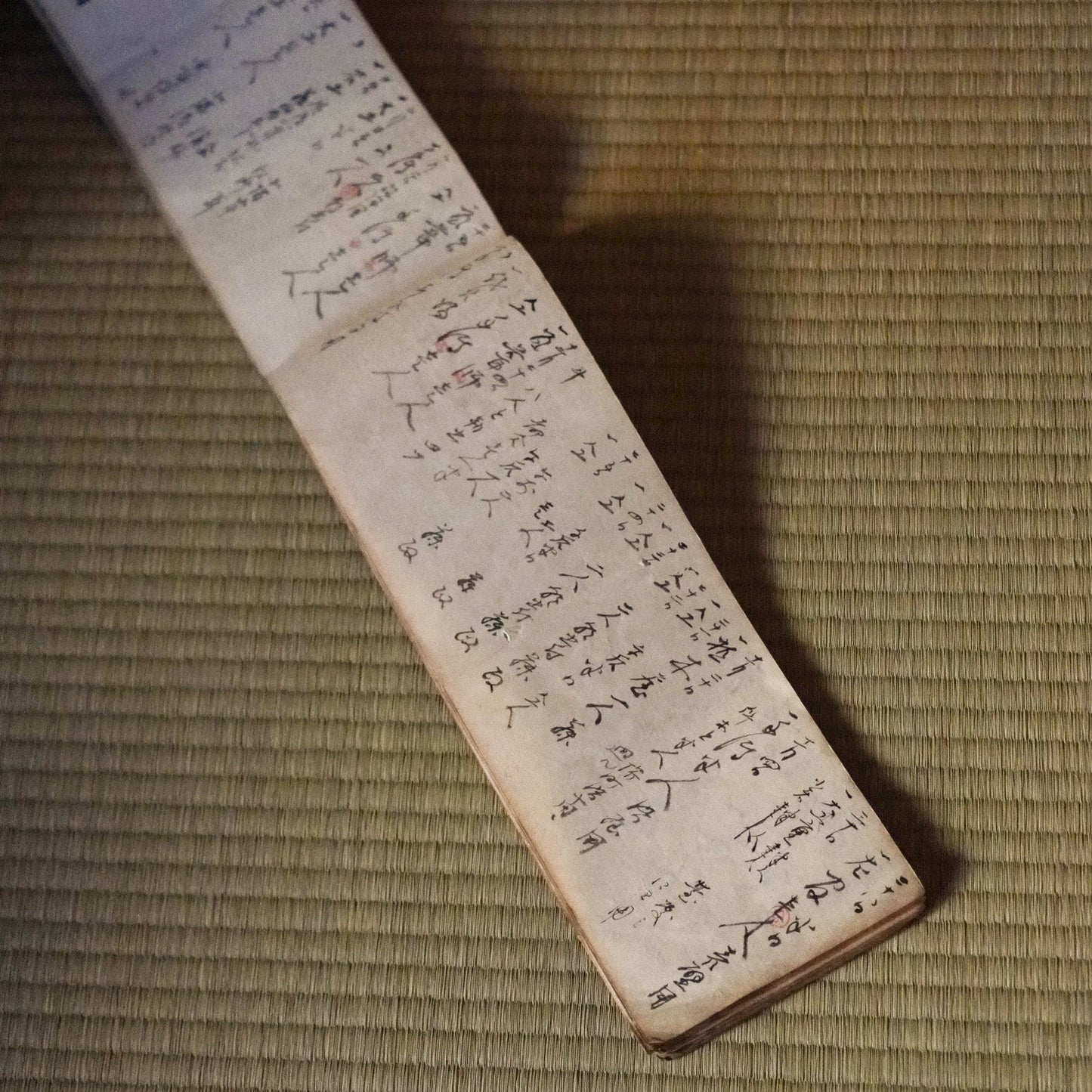 Long japanese ledger book with handwritten text on a textured surface