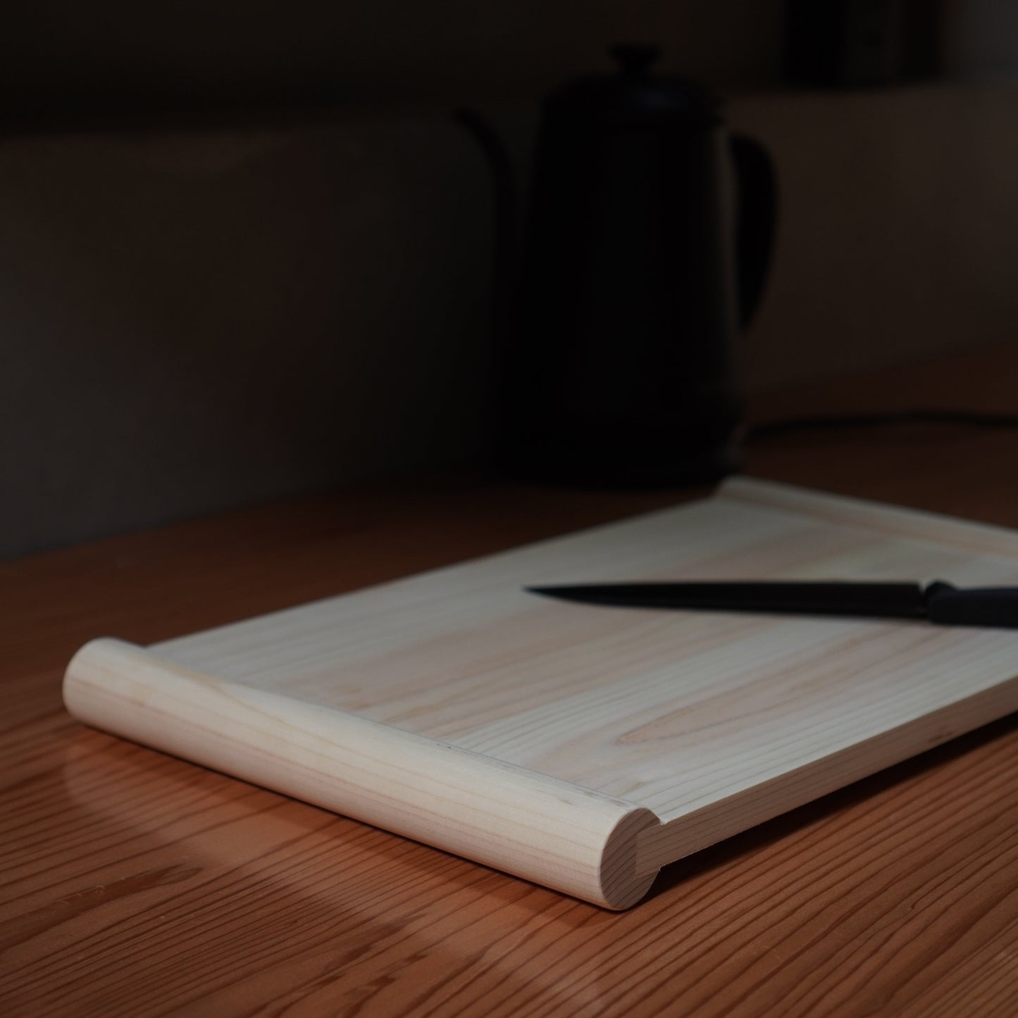 Close-up of a knife on a wooden cutting board with a blurred background