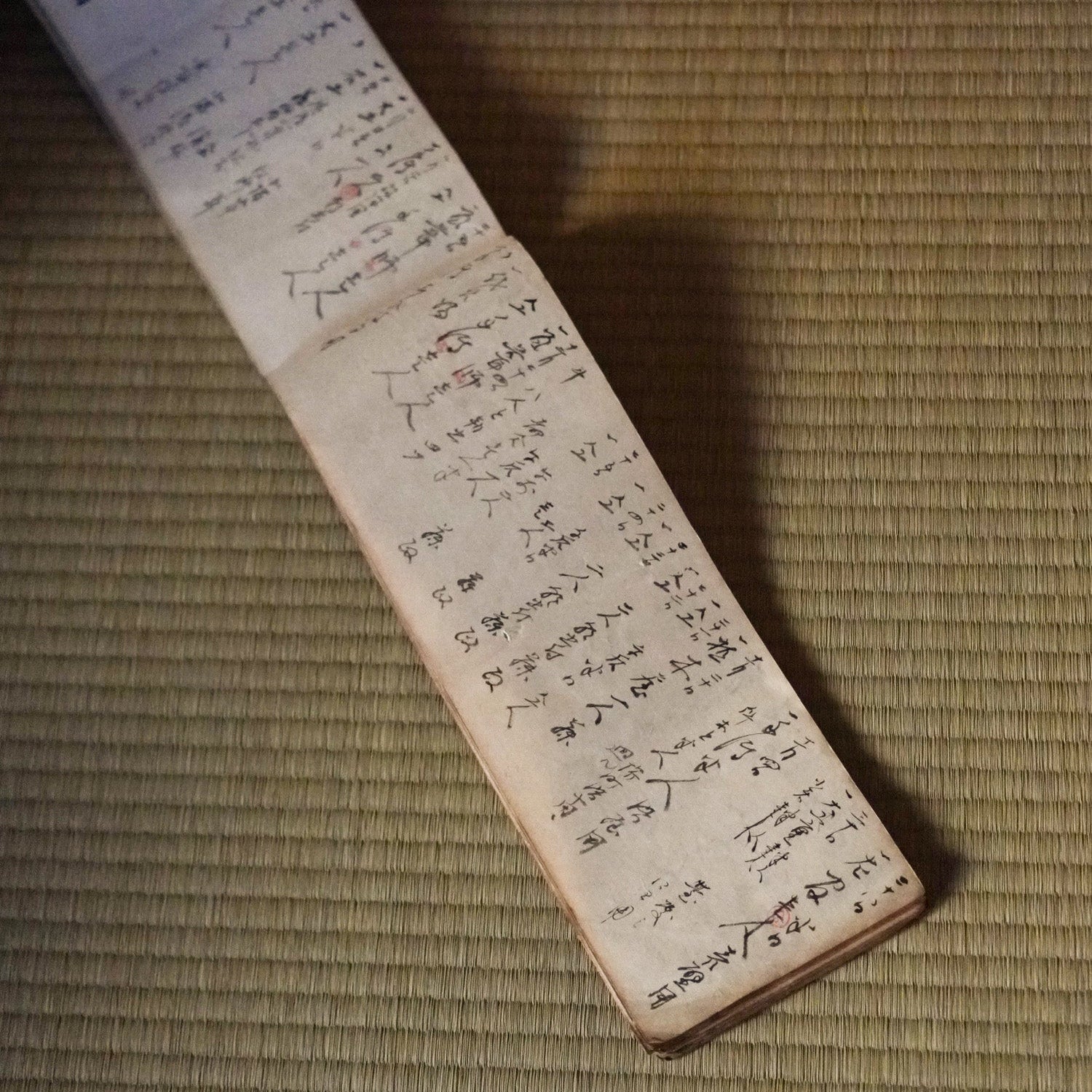 Long japanese ledger book with handwritten text on a textured surface